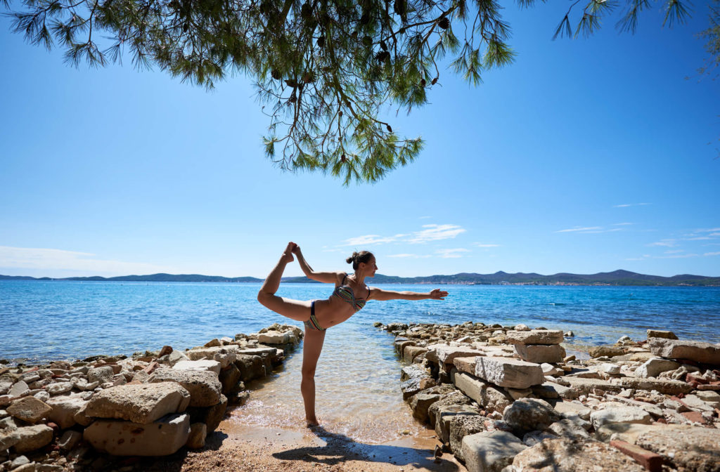 Žena cvičiaca v rovnováhe na pláži